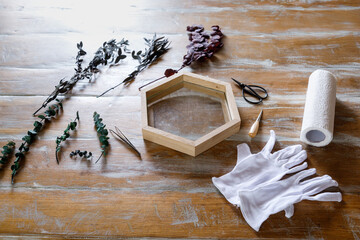 The process of decorating do it yourself. woman works with flowers in a small home workshop. Entrepreneurs lifestyle concept. wooden frames with botanical plants