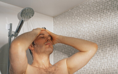 Man taking a shower in bathroom.