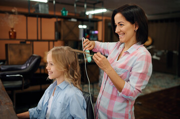 Mother and daughter do hairstyles in hair salon