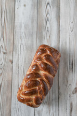 A loaf of fresh white wheat bread on a wooden background.