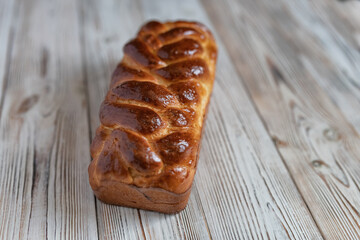 A loaf of fresh white wheat bread on a wooden background.