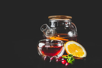 tea pot and Cup of fresh sweet berry tea on black background