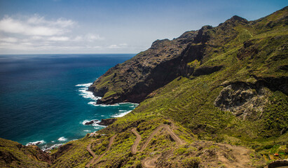 Fototapeta na wymiar Hiking trail descending down to ocean and dramatic cliffs of Anaga mountains in Tenerife