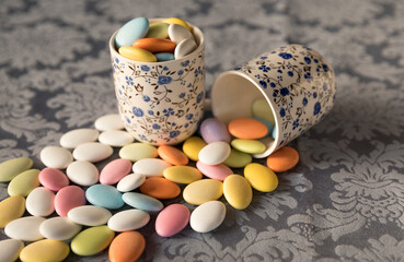 Many almonds inside of porcelain white cups: easter passover with floral pattern, at kitchen table