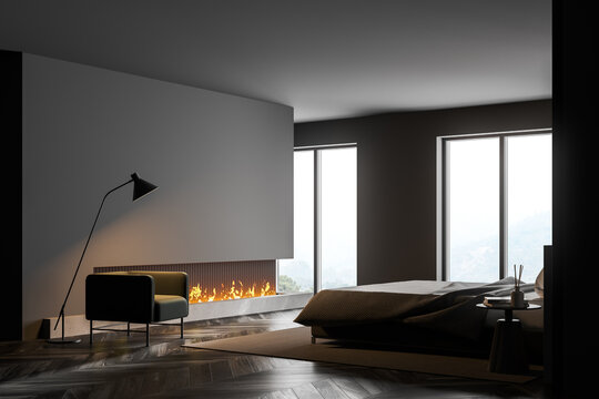 Grey bedroom interior with fireplace, armchair and window, copy space
