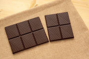 Chocolate bar on rustic sackcloth on a wooden table