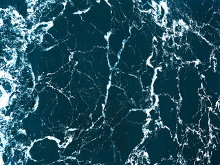 Full frame aerial view of ocean surface and waves - natural abstract dark blue background. Trendy...