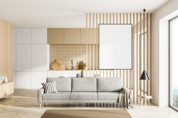 Modern kitchen interior and living room space with panoramic windows with countryside and hills view. Studio apartment. Furnished by beige sofa and one blank framed poster on wooden wall. Mock up.