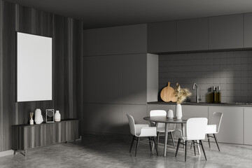 Modern kitchen interior and dining area with table and chairs of studio apartment. Furnished by black oak sideboard and white empty framed poster on dark wooden wall. Mock up.