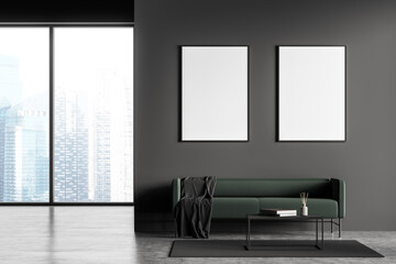 Dark grey modern living room interior with panoramic windows furnished by green sofa, coffee table and two blank posters on wall. Concrete floor. Minimalist design concept.