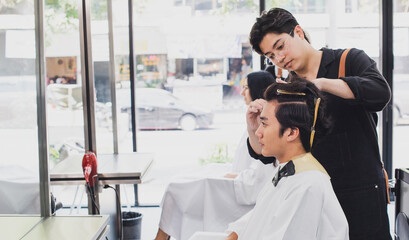 Hairdresser makes the cut for man in the hairdressing salon. Barber shop. Man in barber's chair, hairdresser styling his hair