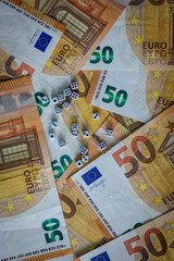 several white dice and euro money