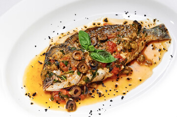 Grilled dorada fish with honey sauce, olives, spices, tomatoes