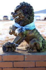 Naklejka premium Buddhist Snow Lion bronze sculpture protecting temple entrance. Beautifully detailed sculpture mythological beast with strong paws and claws 