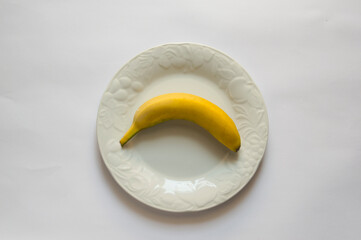 White plate with banana, isolated on white background