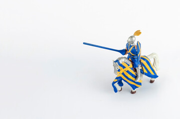 Medieval knight with feathers on his helmet ready to fight on a war horse, isolated on white background with copy space.