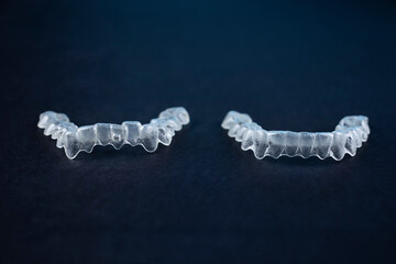 Before and after invisalign invisible brackets. Two transparent aligner retainers, one initial and one final of the same person. Results of orthodontic treatment