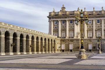 Fototapeta na wymiar Detail of the outer courtyard of the royal palace of Madrid, with lampposts, arches and neoclassical style.