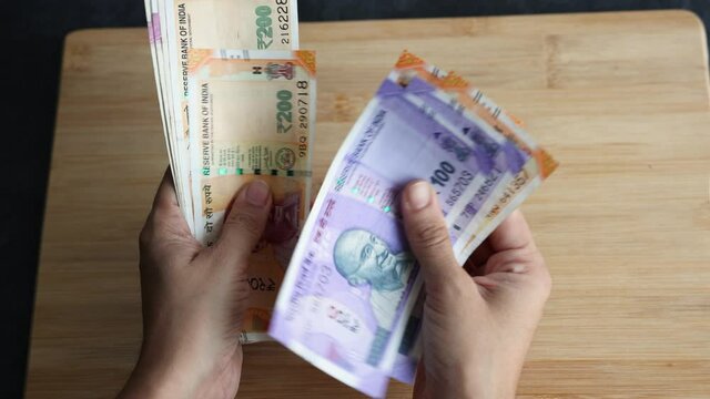 Counting Indian currency Rupee , hand giving Indian money 100, 200, 2000 rupees banknote Kerala India 4K slow motion video, footage. Business woman counting giving money cash new Indian currency notes