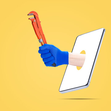 Plumber Hand Showing Monkey Wrench Out From Phone Screen Isolated On Orange Background. Online Plumber Service Concept