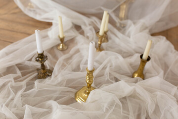 candles in candlesticks. candles in silver candelabra. candles on the fabric. background texture