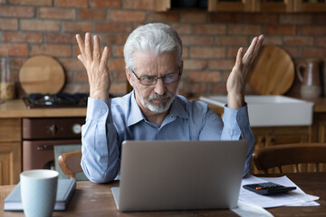 Annoyed worried aged man pensioner sit by laptop unable to make utility bill loan payment online has question how to use app need help. Stressed old grandpa confused with unexpected debt on pc screen