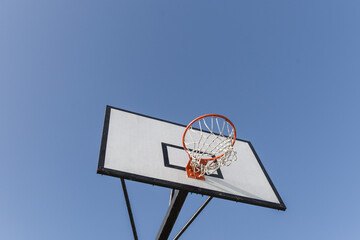 close-up of a basketball basket, rectangular white board with black lines and orange basket with net