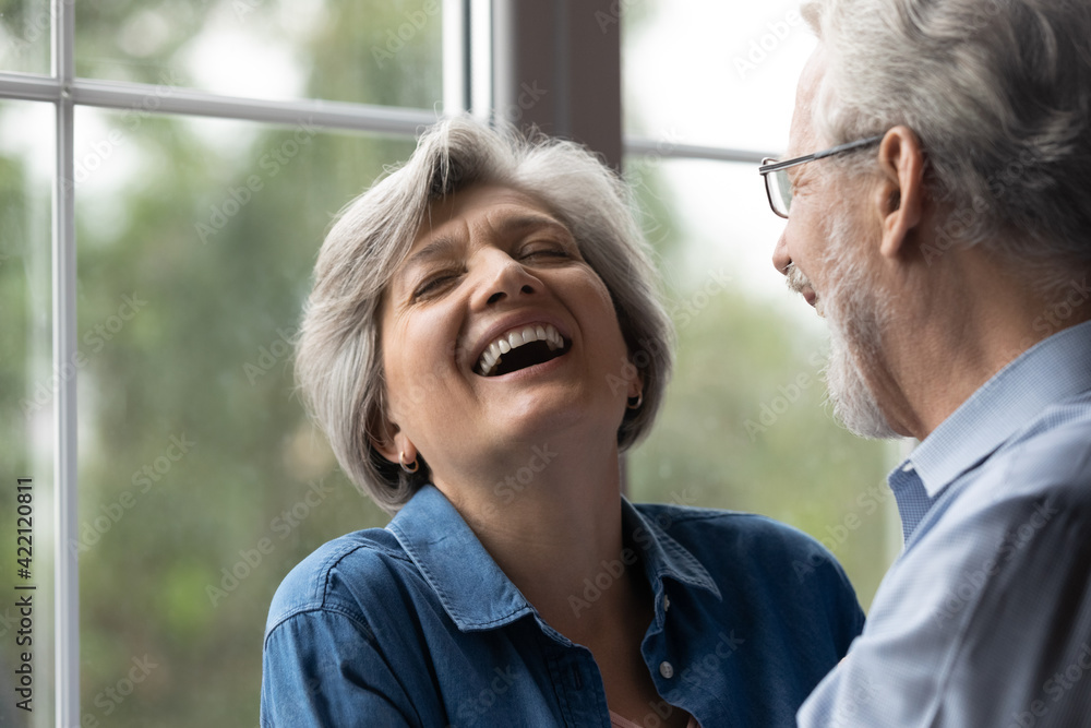 Wall mural close up shot of aged family couple have fun at home laugh recalling amusing incident from youth in 