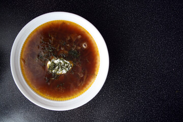 Beetroot soup poured into a white plate. Borsch.