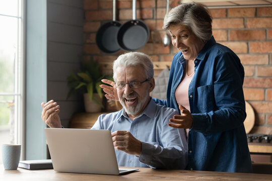 Great Surprise. Overjoyed Mature Married Couple On Pension Scream In Delight Getting Unexpected News Of Prize Award By Email. Excited Old Age Spouses Read About Cash Reward In Betting On Laptop Screen