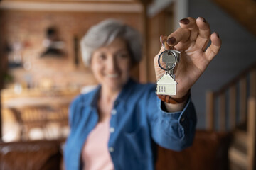 House of dream. Blurred portrait of happy elderly female of senior age becoming landlord homeowner...