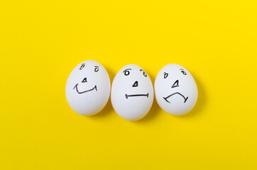 Eggs with emotional faces, on a yellow background.
