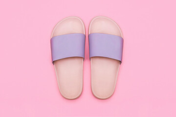 Pink and purple female beach flip-flops isolated on a warm pink background. Summer concept