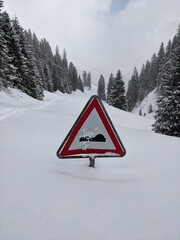 traffic sign sinks in the snow. Snow-covered pass road in the swiss mountains. Pragelpass from glaurs to the muotathal