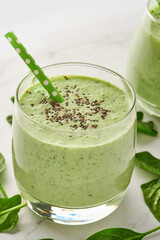 Detox green smoothie with spinach, chia seeds and kiwi on a light gray slate, stone or concrete background. Top view with copy space.