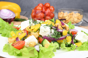 A close view on greek salad on a big white plate.