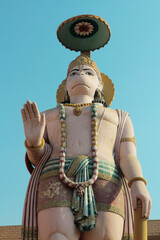 A huge sculpture of Hanuman against a blue sky in Vrndavana, India.