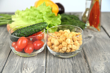 Red tomatoes and white bread croutons in transparent glass bowls