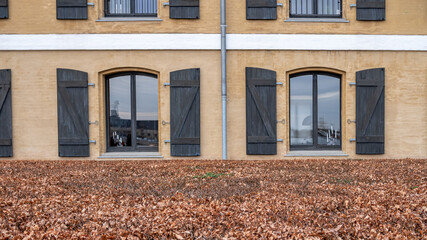 The facade of a historic building with large windows and shutters in Copenhagen