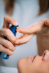Retinol Treatment. Cosmetician Applying Retinol Serum on Woman’s Face