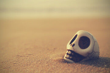 Fototapeta na wymiar Skull in the sand with a blurry space for text. Abstract pessimistic background. Vintage toning.
