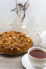 Sponge cake with  apples in a cast-iron pan, homemade, tea and kettle on the table