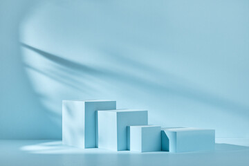 Blue background for product presentation with shadows and light. Empty podiums. Mockup.