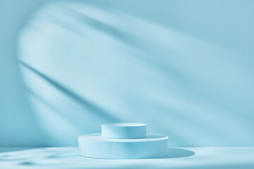 Blue background for product presentation with shadows and light. Empty round podiums. Mockup.