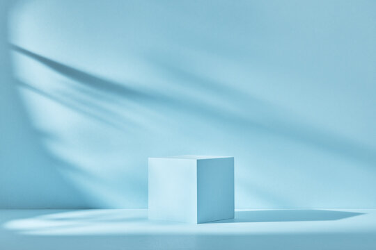 Blue background for product presentation with shadows and light. Empty cubic podium. Mockup.