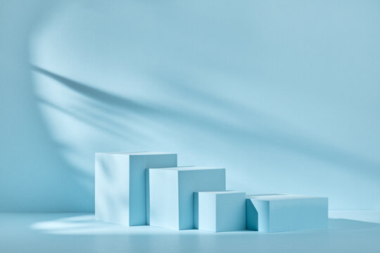 Blue background for product presentation with shadows and light. Empty podiums. Mockup.