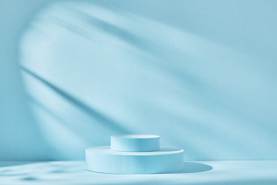 Blue background for product presentation with shadows and light. Empty round podiums. Mockup.