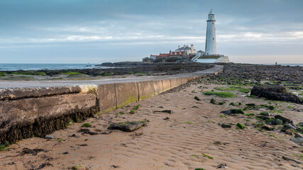 Whitley Bay on the north east coast of England, UK. Looking towards St Marys Lighthouse over the causeway on an overcast morning at dawn.