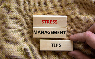 Stress management tips symbol. Wooden blocks with words 'Stress management tips'. Beautiful canvas background. Doctor hand. Psychological, business and stress management tips concept. Copy space.