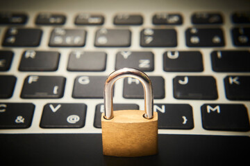 Computer security concept. Unlocked padlock on notebook keyboard. Symbol of safe. Selective focus
